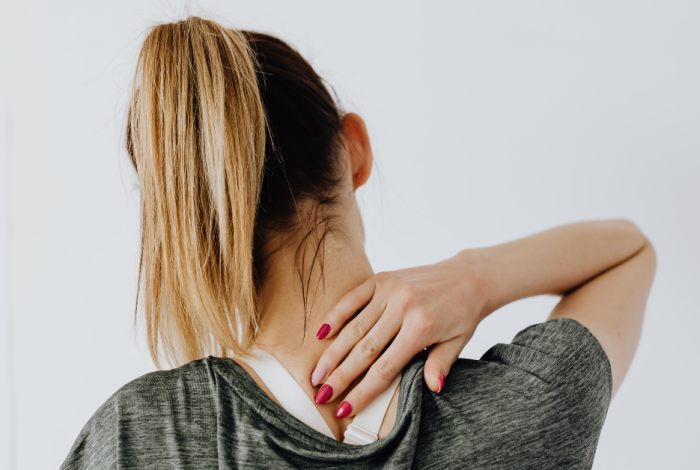 Person holding their neck due to pain, representing neck pain treatment at LivFit Physio Mornington